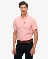 Superdry Koszula Oxford krótki rękaw Rose Pink Chambray z bawełny organicznej. Czerwone koszule Superdry, l, bez wzorów, z bawełny, bez kołnierzyka, bez ramiączek. Za 336.50 zł.